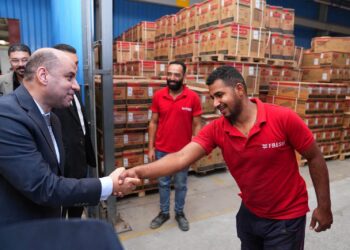 وزير العمل يتحدث لأحد العمال خلال الزيارة