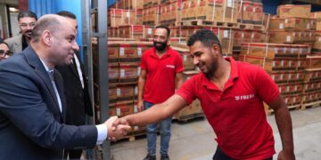 وزير العمل يتحدث لأحد العمال خلال الزيارة