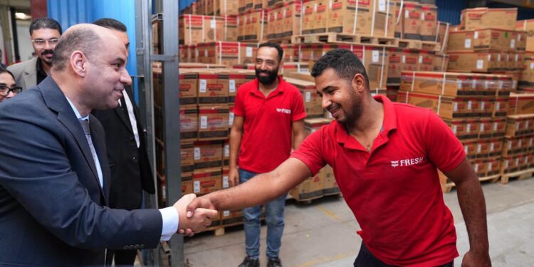 وزير العمل يتحدث لأحد العمال خلال الزيارة